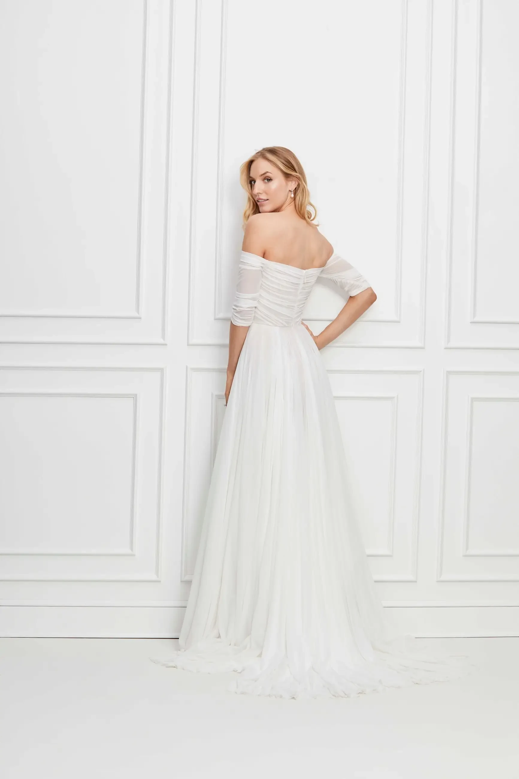 model is wearing an off the shoulder a-line bridal gown