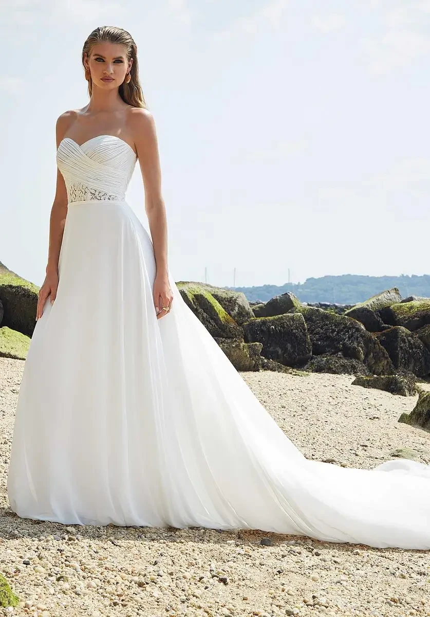 model is wearing an a-line bridal gown with off the shoulder short sleeves