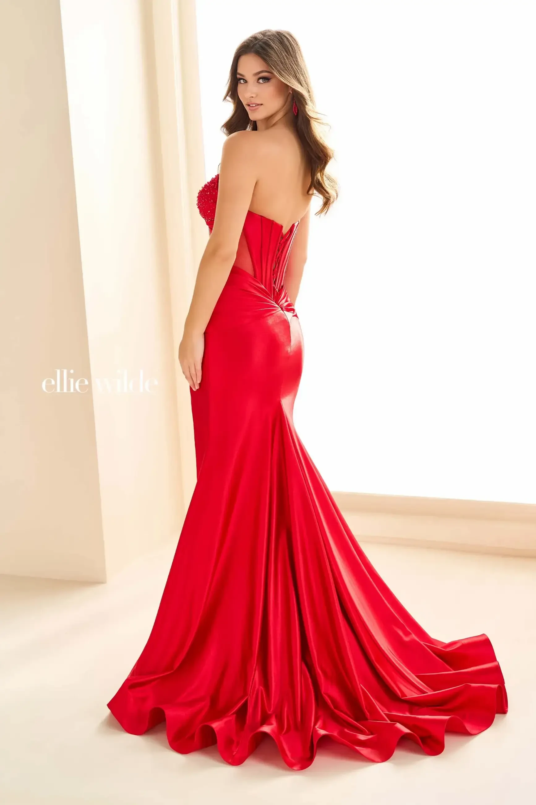 model is wearing a strapless red fit and flare prom dress